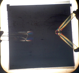 Stressed plastic pieces between crossed polarizers